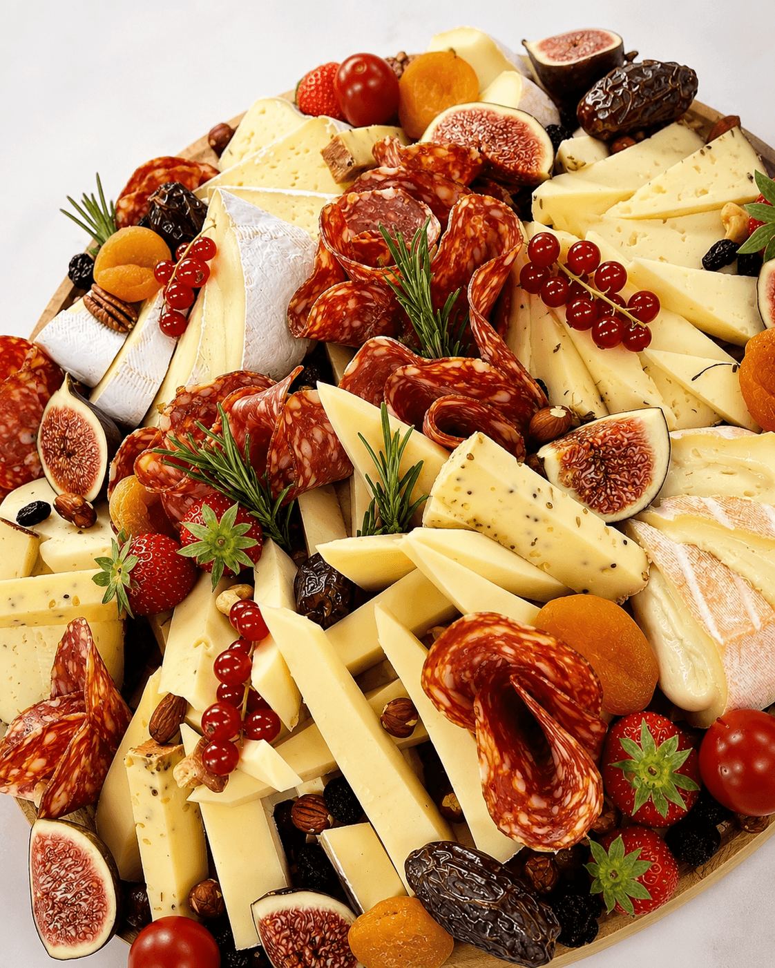 Kaas- en vleesplank met salami, vijgen, rode bessen en aardbeien
